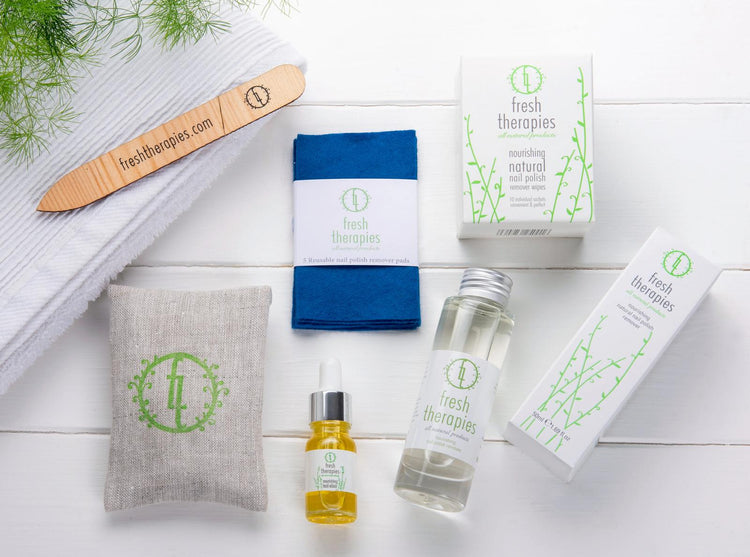 Fresh Therapies natural nail polish remover and nail care products on a wooden background.