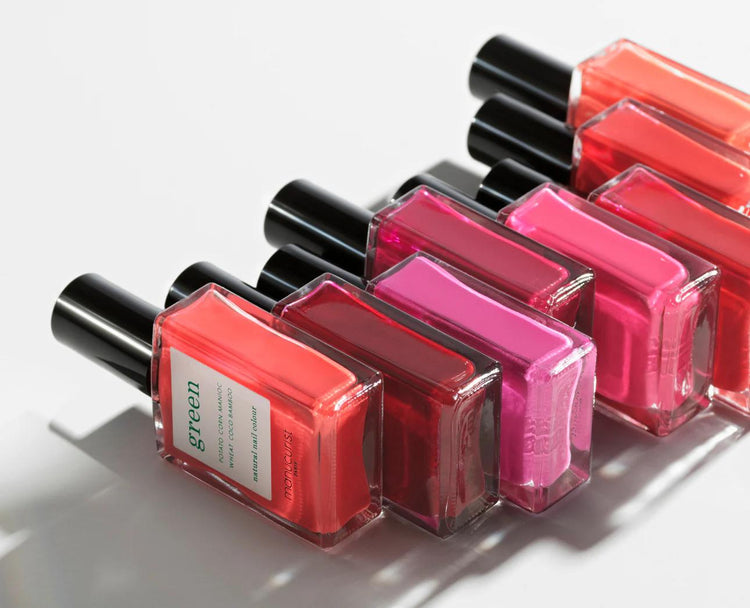 Vibrant assortment of nail polish bottles in red and pink hues, showcasing cruelty-free and non-toxic options.