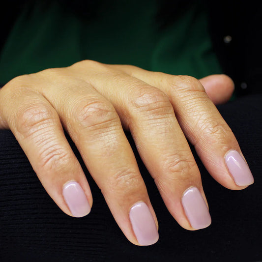 Hand with light skin tone wearing Bio Sculpture Gemini Nail Polish No. 2062 Dawn – vegan, light grey-taupe polish for a chic, understated nail look