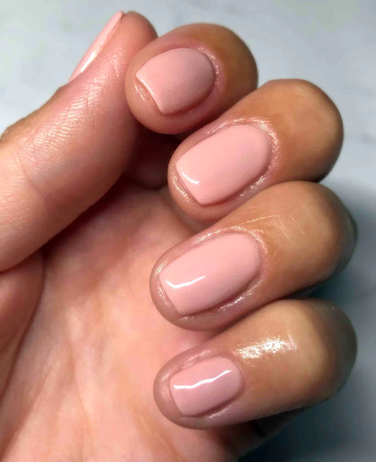 Hand wearing Bio Sculpture Gemini Nail Polish No. 230 Pink Foundation – vegan, soft powder pink polish for a chic, understated nail look