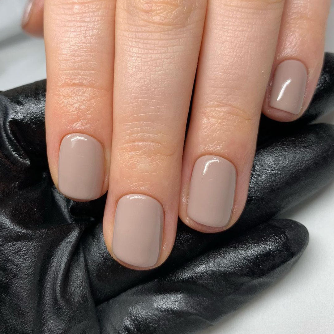 Fingers painted with Bio Sculpture Gemini Nail Polish No. 122 Ashes of Roses on light skin – breathable, muted rose polish for a polished, sophisticated style