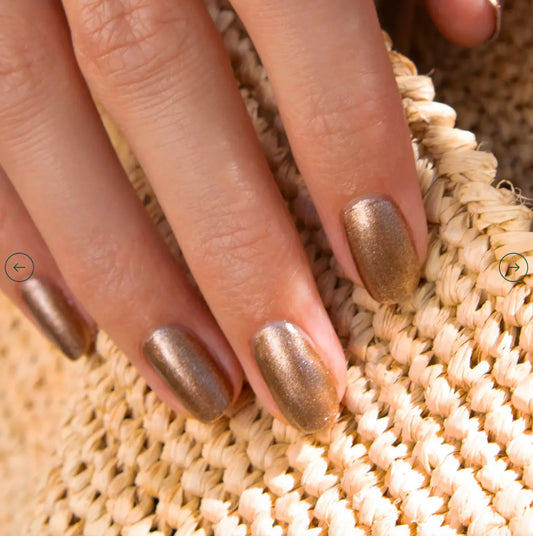 Hand with light skin tone wearing Manucurist Bronzé – shimmery, vegan bronze polish for a radiant, elegant manicure
