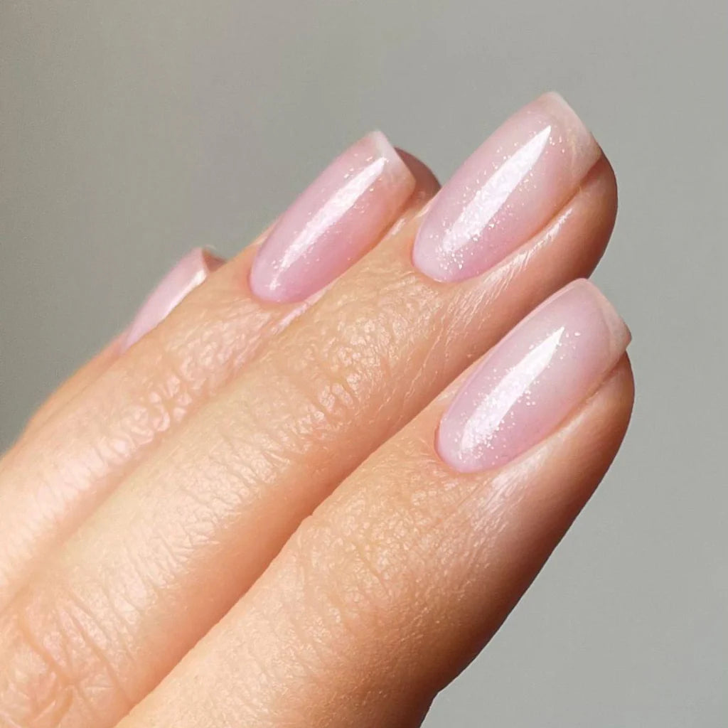 Fingers painted with Gemini Baby Heart Confetti on light skin – breathable, pink confetti polish for a modern, creative style