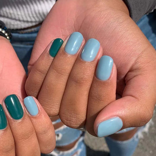 Hand wearing Bio Sculpture Gemini Nail Polish No. 263 Blue Ballad – vegan, dusty muted blue polish for a chic, modern nail look