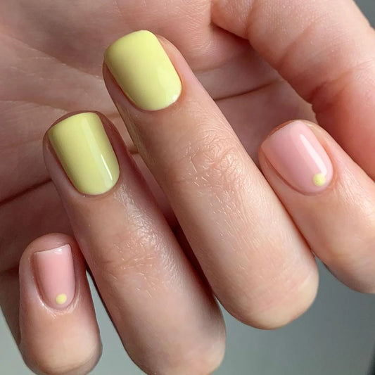 Hand wearing Bio Sculpture Gemini Nail Polish No. 156 Brigitte – vegan, pastel yellow polish for a fresh, sunny nail loo