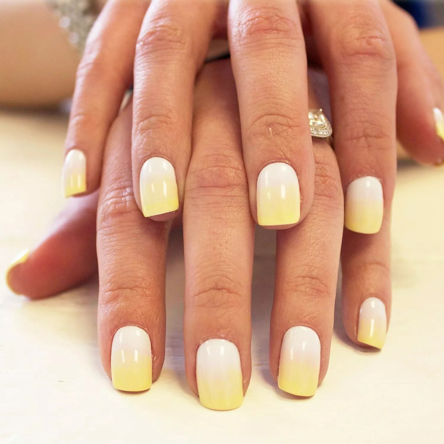 Hand wearing Bio Sculpture Gemini Nail Polish No. 156 Brigitte – bold, vegan pastel yellow polish for inclusive, radiant manicures