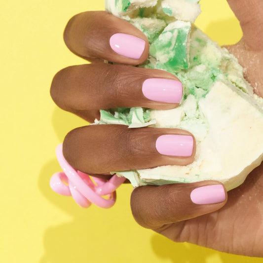 Hand with dark skin tone wearing Manucurist Candy – gentle, eco-friendly pastel pink polish for inclusive, elegant nail looks