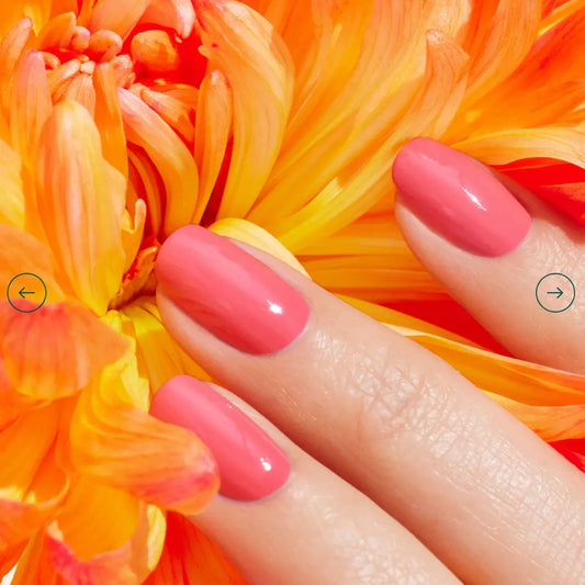 Hand with light skin tone wearing Manucurist Capucine – bright, vegan orange polish for a lively, modern manicure