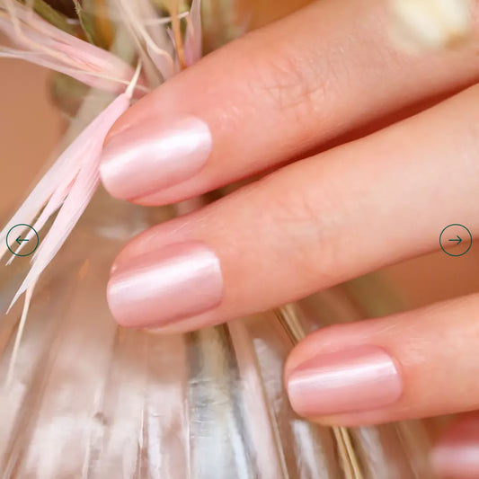 Hand with nails painted in Manucurist Carnation – soft pink vegan polish for a fresh, feminine manicure