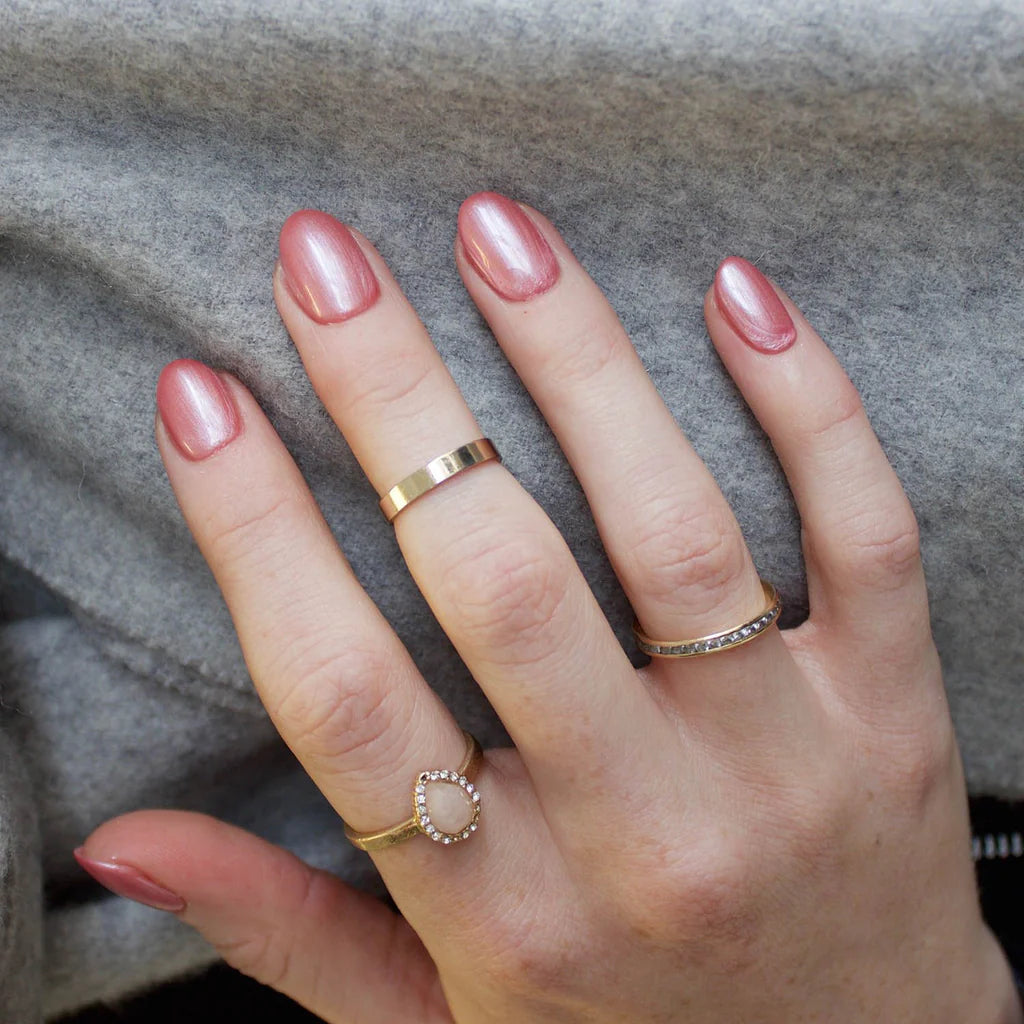 Hand wearing Bio Sculpture Gemini Nail Polish No. 7 Candy Floss – vegan, metallic pearly-pink polish with a pearlescent sheen for a chic, radiant nail look