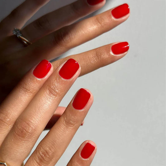 Hand wearing Bio Sculpture Gemini Nail Polish No. 20 Cherry Ripe Red – vegan, cherry red polish for a vibrant, elegant nail look