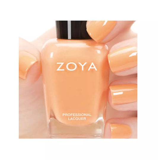 Hand holding Zoya Cole nail polish – soft, non-toxic peach shade for elegant, modern nail looks
