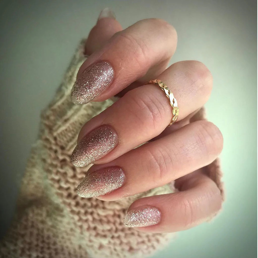 Hand wearing Bio Sculpture Gemini Nail Polish No. 220 Shine Like a Disco Ball – vegan, stunning rose gold glitter polish for a glamorous, eye-catching nail look