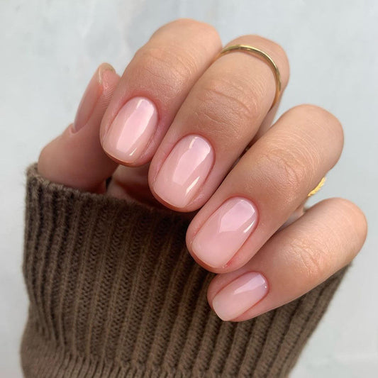 Hand with light skin tone wearing Bio Sculpture Gemini Nail Polish No. 68 French Rose – vegan, soft creamy pink polish for a chic, understated nail look