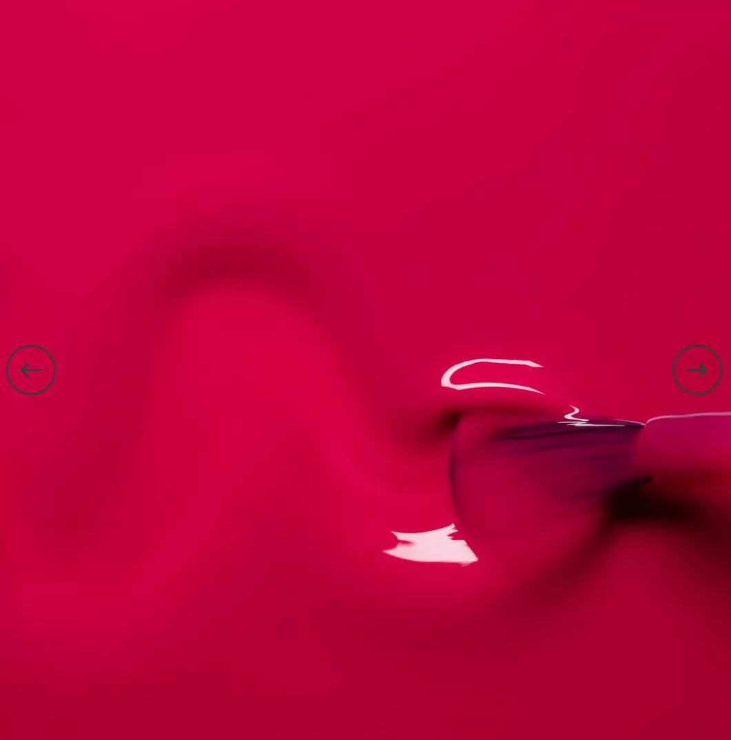 Polish brush dipped in Manucurist Fuchsia nail polish – creamy, non-toxic fuchsia formula for smooth, even application