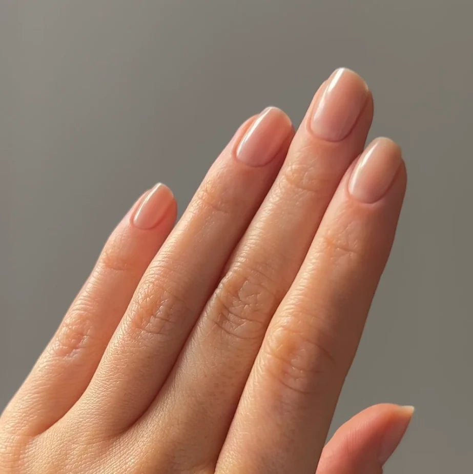 Hand with light skin tone wearing Bio Sculpture Gemini Nail Polish No. 67 French Creme – vegan, creamy off-white polish for a chic, classic French manicure