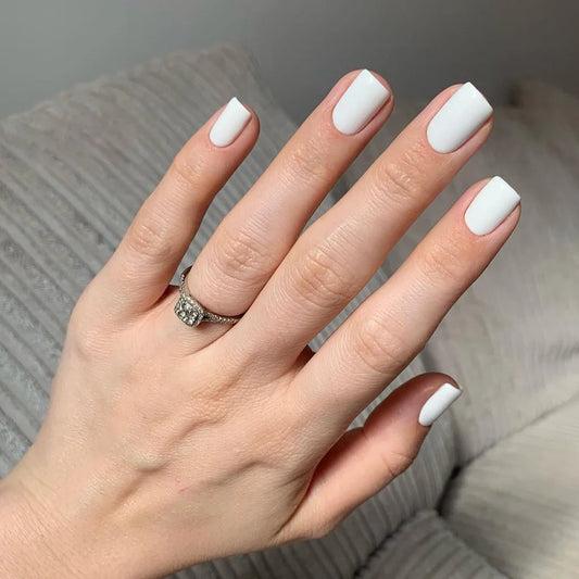 Hand wearing Bio Sculpture Gemini Nail Polish No. 1 French White – vegan, opaque stark white polish for a crisp, timeless French manicure look