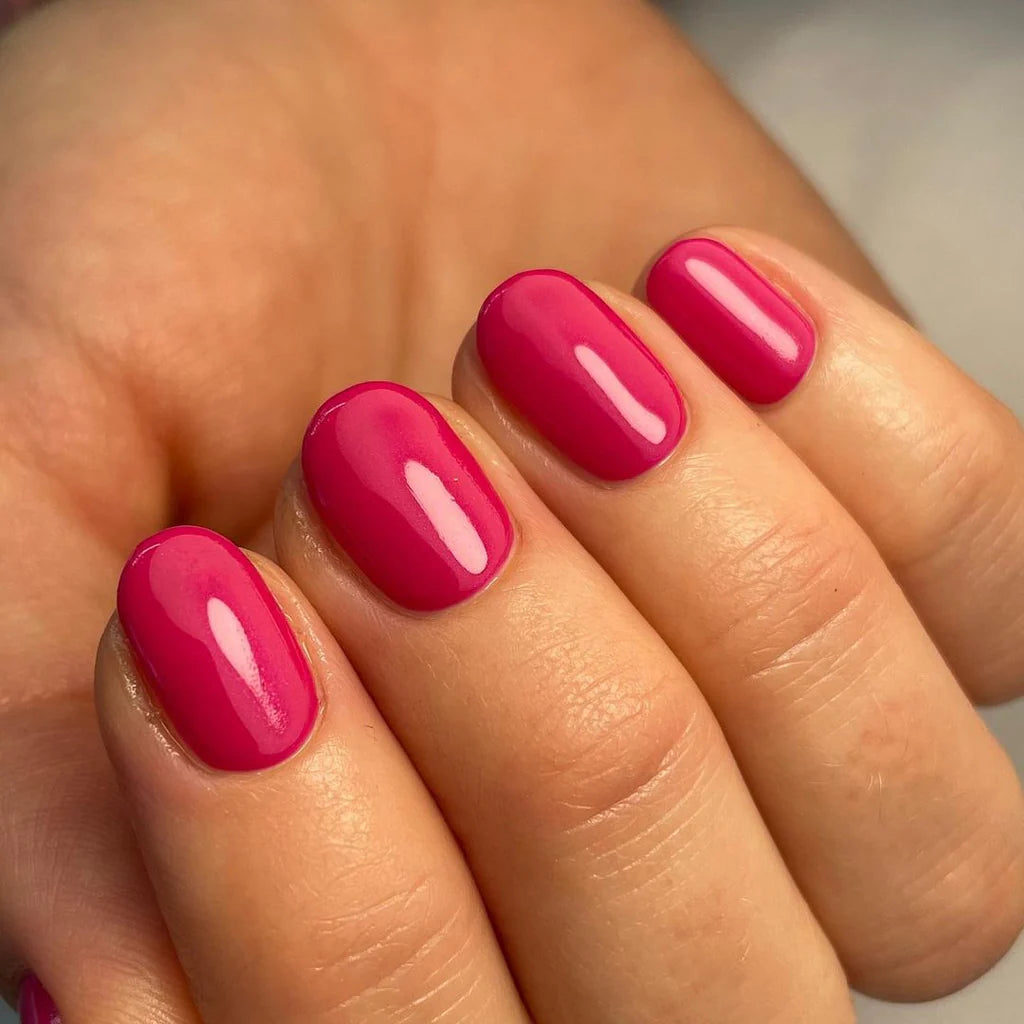 Hand with light skin tone wearing Bio Sculpture Gemini Nail Polish No. 2016 Funky Fuchsia – vegan, vibrant fuchsia pink polish for a chic, energetic nail look