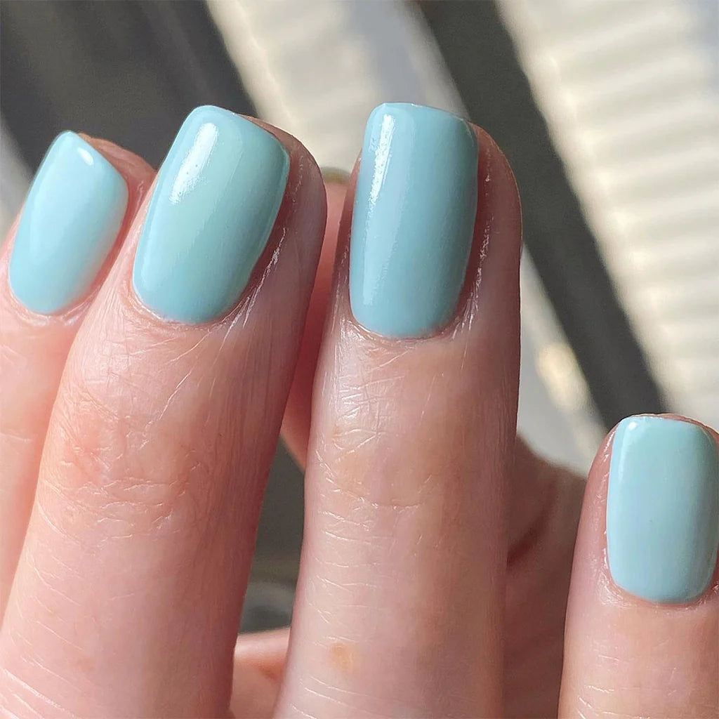 Hand wearing Bio Sculpture Gemini Nail Polish No. 159 G Grace – bold, vegan light mint blue polish for inclusive, radiant manicures