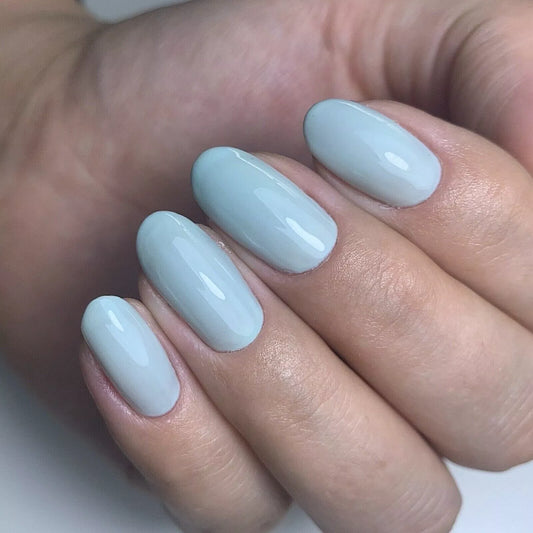 Hand with light skin tone wearing Bio Sculpture Gemini Nail Polish No. 159 G Grace – vegan, light mint blue polish for a chic, delicate nail look