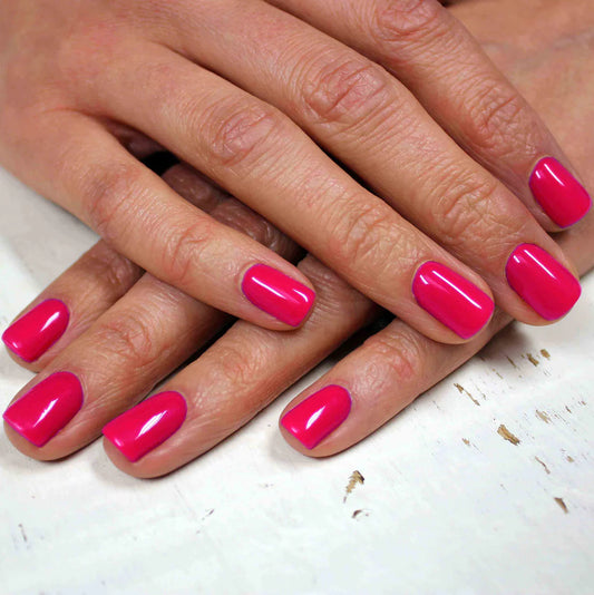 Hand with light skin tone wearing Bio Sculpture Gemini Nail Polish No. 173 Ipanema Sunset – vegan, hot pink polish for a chic, energetic nail look