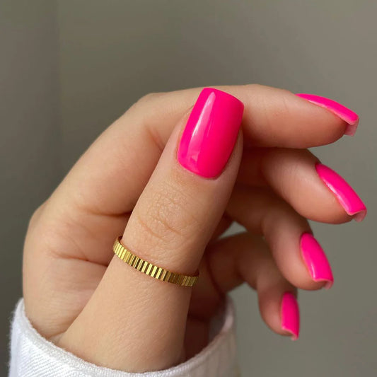 Hand wearing Bio Sculpture Gemini Nail Polish No. 105 Jinkie Pink – vegan, fluorescent bright pink polish for a vibrant, statement nail look