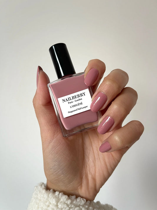 Hand with darker skin tone wearing Nailberry Love Me Tender – soft, vegan pink polish for sophisticated, inclusive manicures