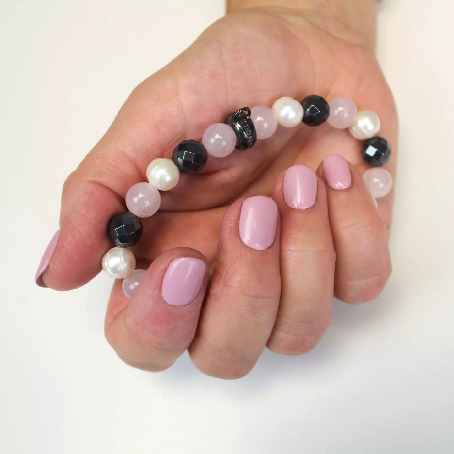 Hand wearing Bio Sculpture Gemini Nail Polish No. 235 Love – bold, vegan pastel pink polish for inclusive, radiant manicure