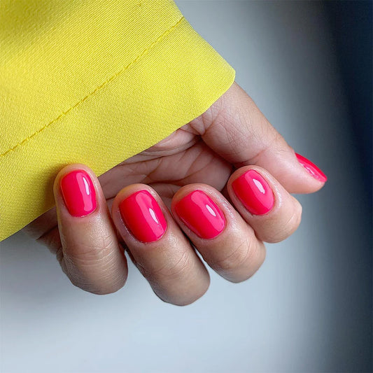Hand wearing Bio Sculpture Gemini Nail Polish No. 101 Luminous Watermelon – vegan, radiant fluorescent light pink polish for a vibrant, eye-catching nail look