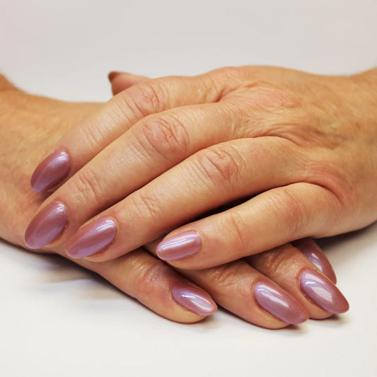 Hand with light skin tone wearing Bio Sculpture Gemini Nail Polish No. 219 Magical Merry-Go-Round – vegan, pearlescent pink polish for a chic, radiant nail look