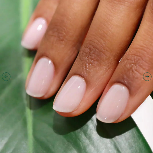Hand with darker skin tone wearing Manucurist Milky White – soft, vegan white polish for elegant, inclusive manicures