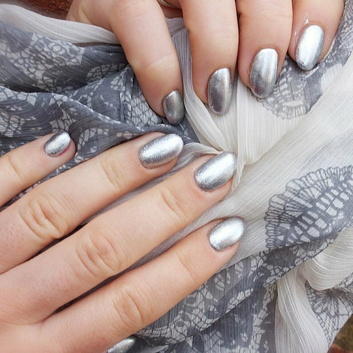 Nails featuring Bio Sculpture Gemini Nail Polish No. 138 Melting Mercury on light skin – cruelty-free, futuristic silver polish for an elegant, eye-catching finish