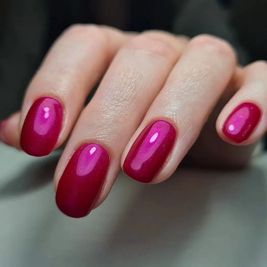 Close-up of manicured nails featuring Bio Sculpture Gemini Nail Polish No. 215 in a vibrant magenta shade.