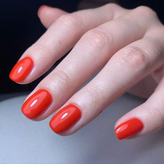 Hand with light skin tone wearing Bio Sculpture Gemini Nail Polish No. 17 Tropical Flame – vegan, flaming orange red polish for a chic, energetic nail look