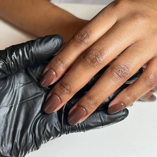 Close-up of Bio Sculpture Gemini Nail Polish No. 2009 Hot Chocolate polish on dark skin – eco-friendly, rich brown shade for glowing, beautiful nails