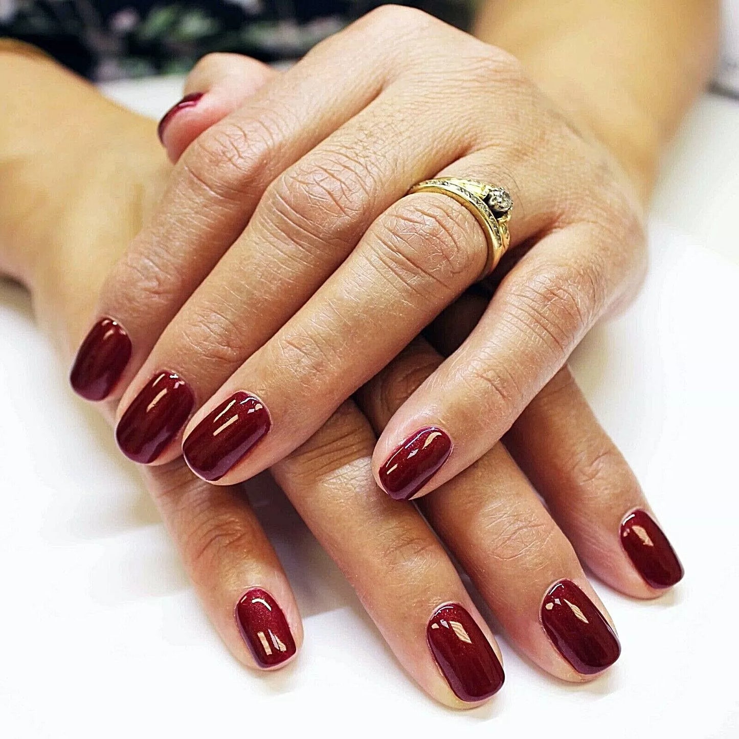 Fingers painted with Bio Sculpture Gemini Nail Polish No. 2024 Claret on light skin – breathable, creamy claret red polish for a polished, timeless style