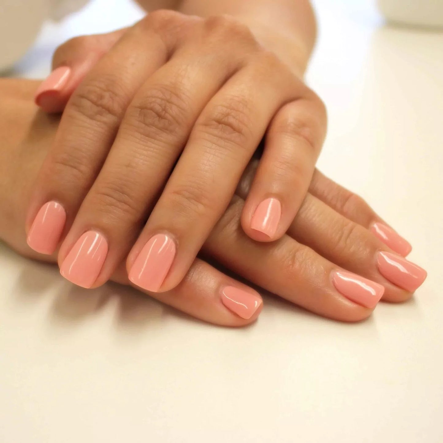 Hand with light skin tone wearing Bio Sculpture Gemini Nail Polish No. 246 Island Surf – vegan, creamy soft pastel coral polish for a chic, delicate nail look