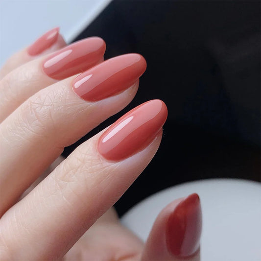 Hand wearing Bio Sculpture Gemini Nail Polish No. 260 Poetic Poise – vegan, dusky rosy red polish for a chic, sophisticated nail look