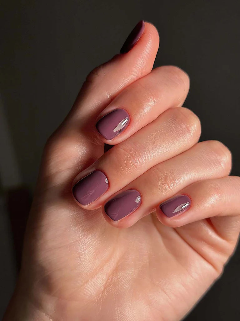Hand with medium skin tone wearing Bio Sculpture Gemini Nail Polish No. 265 Chipped Bark – vegan, rich deep purple polish for a versatile, modern manicure