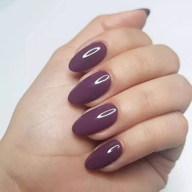 Hand with dark skin tone wearing Bio Sculpture Gemini Nail Polish No. 265 Chipped Bark – bold, vegan deep purple polish for inclusive, striking manicures