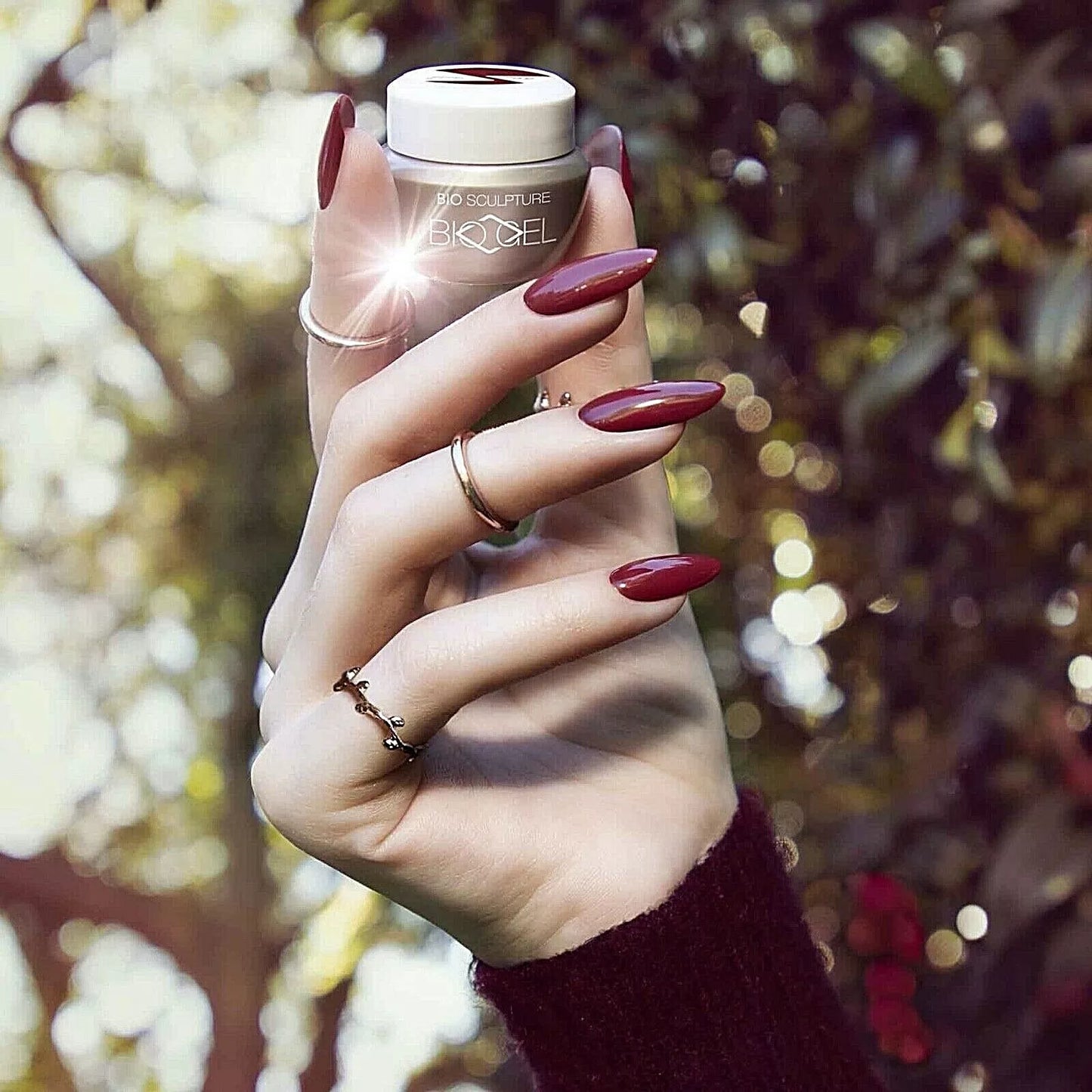 Hand with dark skin tone wearing Bio Sculpture Gemini Nail Polish No. 269 Berry Bush – bold, vegan berry purple polish for inclusive, radiant manicures
