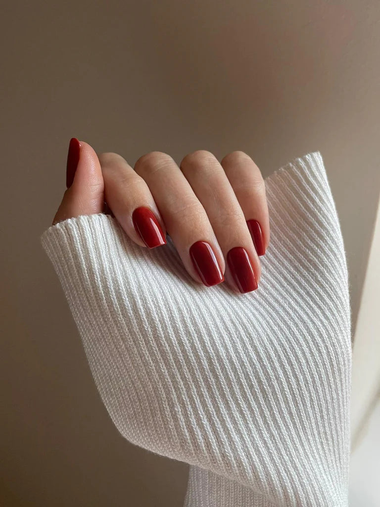 Fingers painted with Bio Sculpture Gemini Nail Polish No. 276 Rosi Red on light skin – breathable, rosy red polish for a polished, everyday style