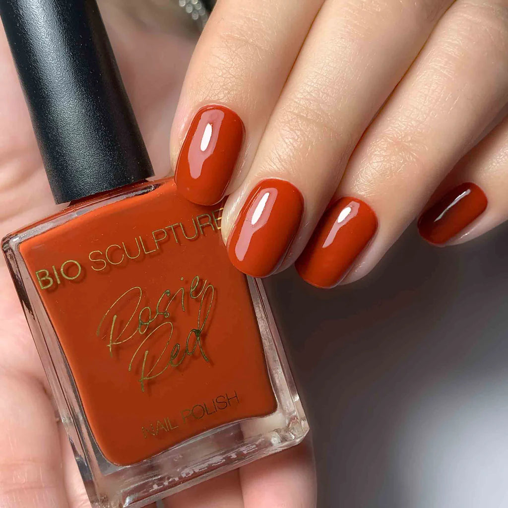 Hand with Bio Sculpture Gemini Nail Polish No. 276, Rosi Red nail polish bottle – bold rosy red vegan polish for a chic, elegant manicure