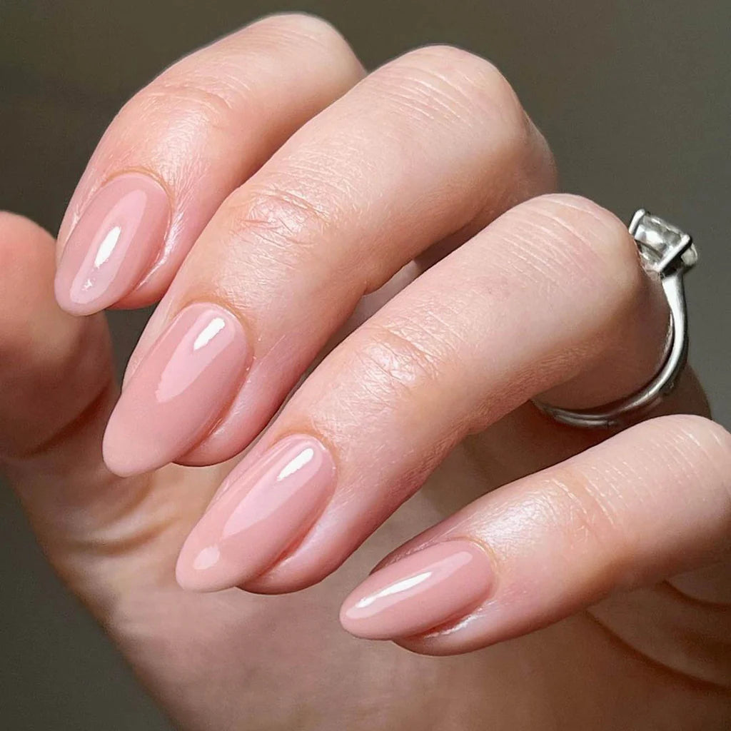 Hand wearing Bio Sculpture Gemini Nail Polish No. 261 Lyrics of a Lily – vegan, vintage nude polish for a chic, understated nail look"