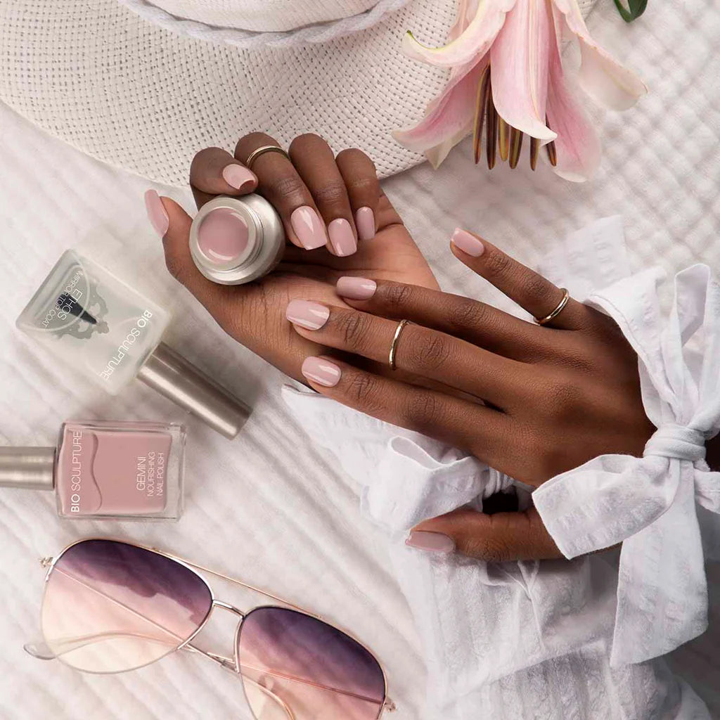 Hand with Bio Sculpture Gemini Nail Polish No. 274 Perky Pollen nail polish bottle – soft nude pink vegan polish for a chic, sophisticated manicure