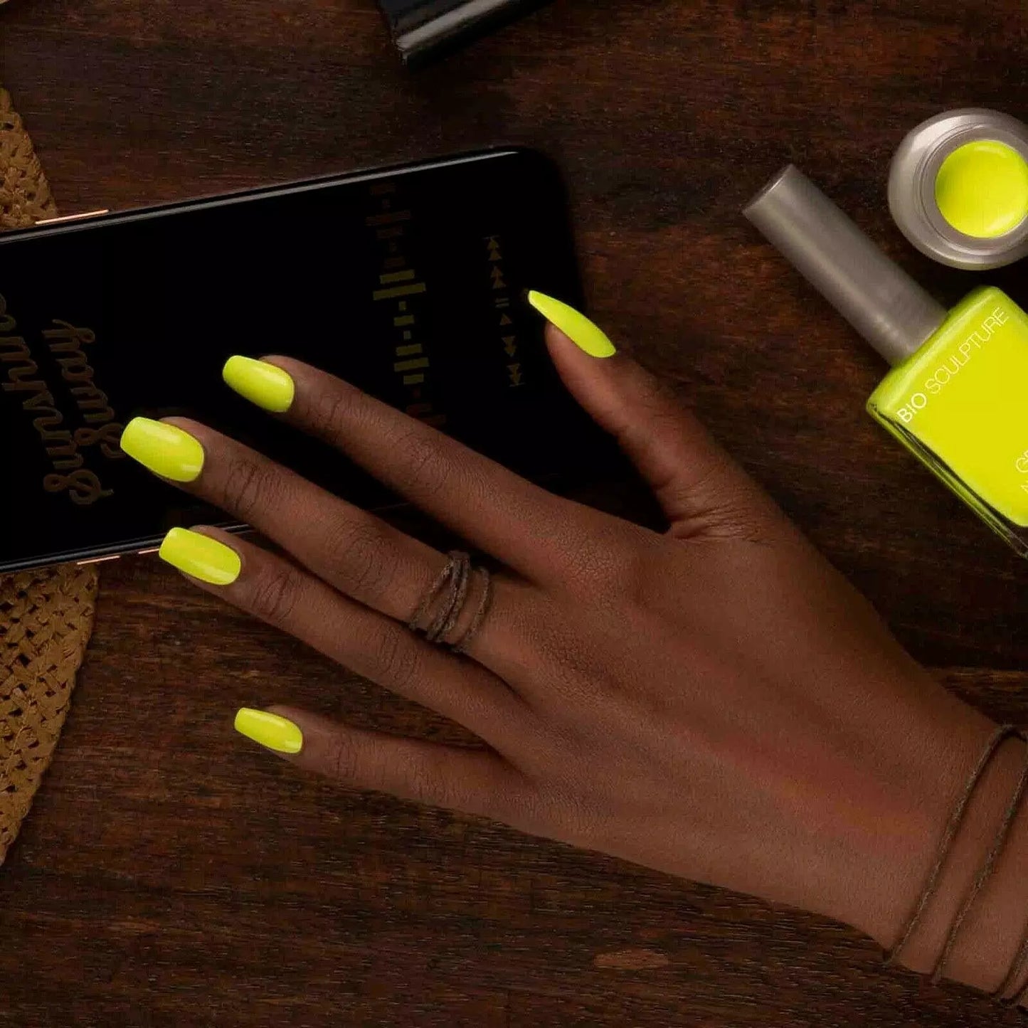 Close-up of Bio Sculpture Nail Polish No. 283, Sunshine Sway polish on dark skin – eco-friendly, bright yellow shade for glowing, stylish nails
