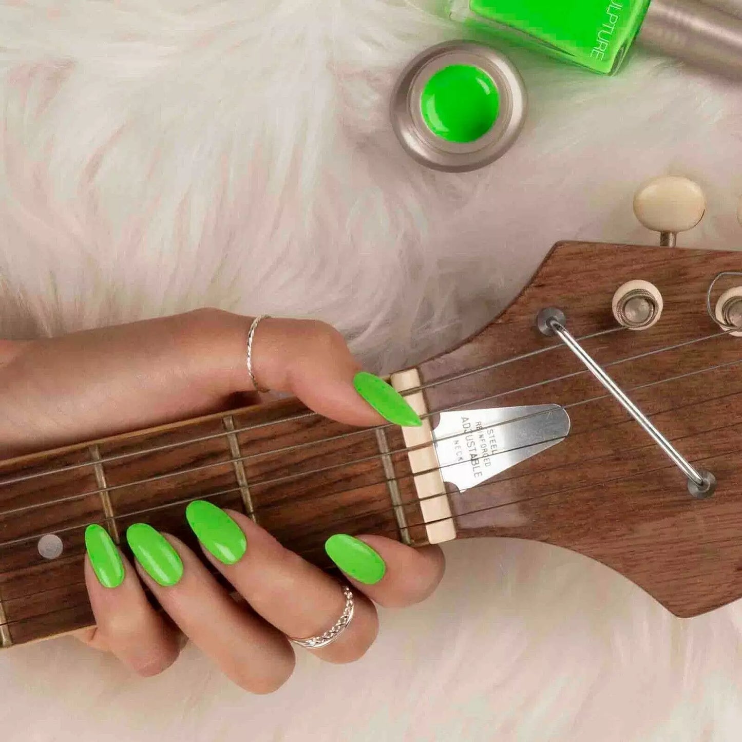 Hand with Bio Sculpture Limelight nail polish bottle – bold lime green vegan polish for a fresh, trendy manicure