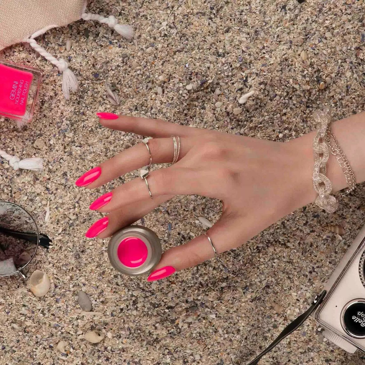 Hand holding Bio Sculpture Gemini Nail Polish No. 28, Belle of the Bop nail polish – vegan, fuchsia pink polish bottle for stylish, energetic nails