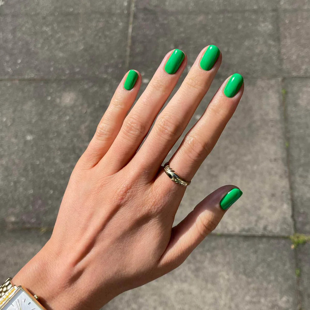 Close-up of Verde polish on light skin – non-toxic, bright green shade for a chic, contemporary nail look