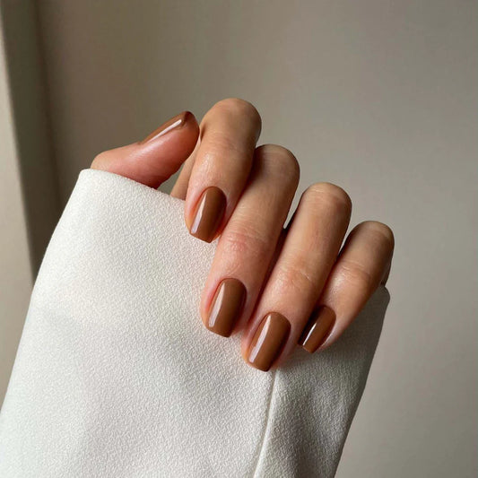 Fingers painted with Gemini Dust at Dusk – breathable, taupe polish for a refined, minimalist style